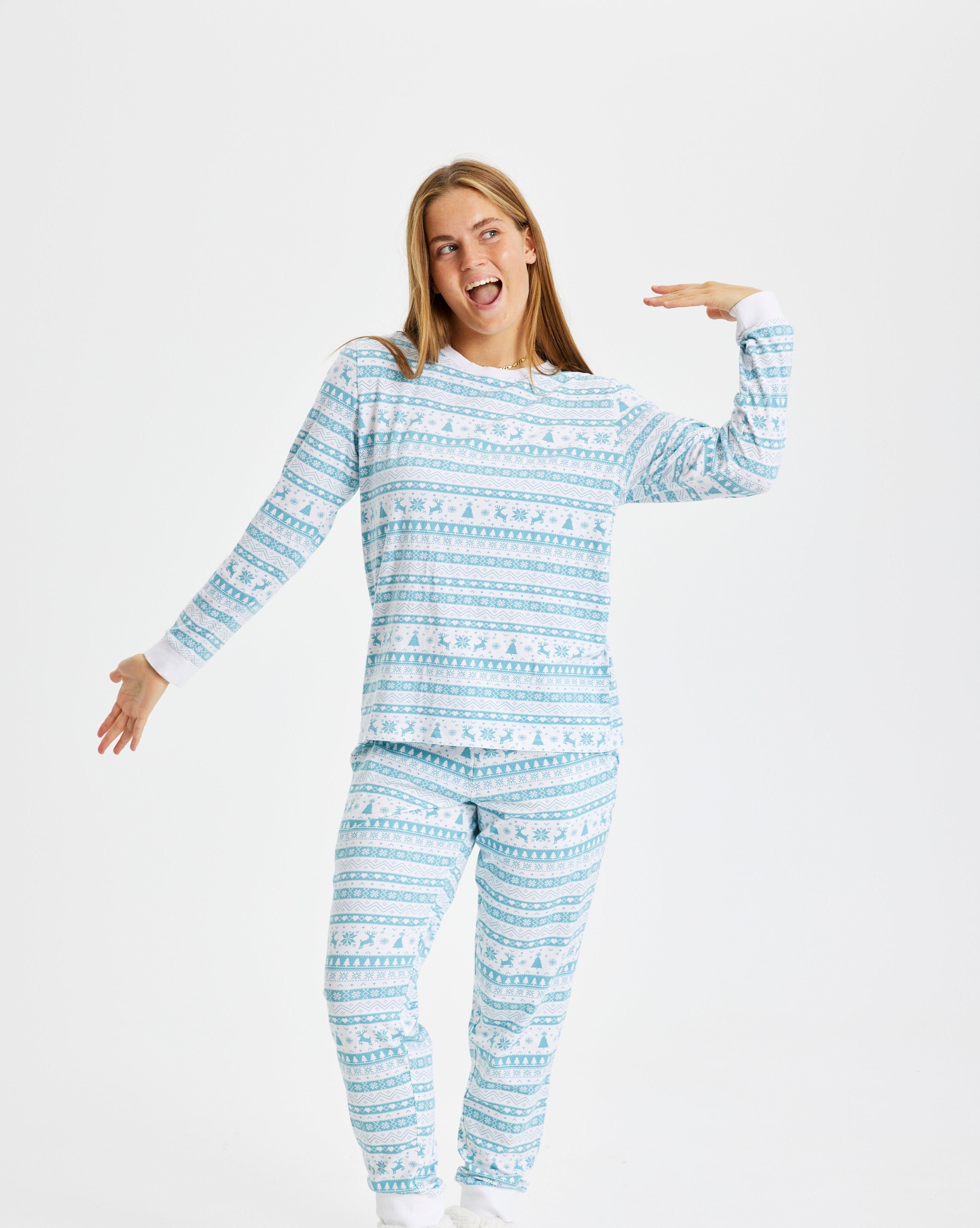 En kvinne i blå julepyjamas med julemønster.